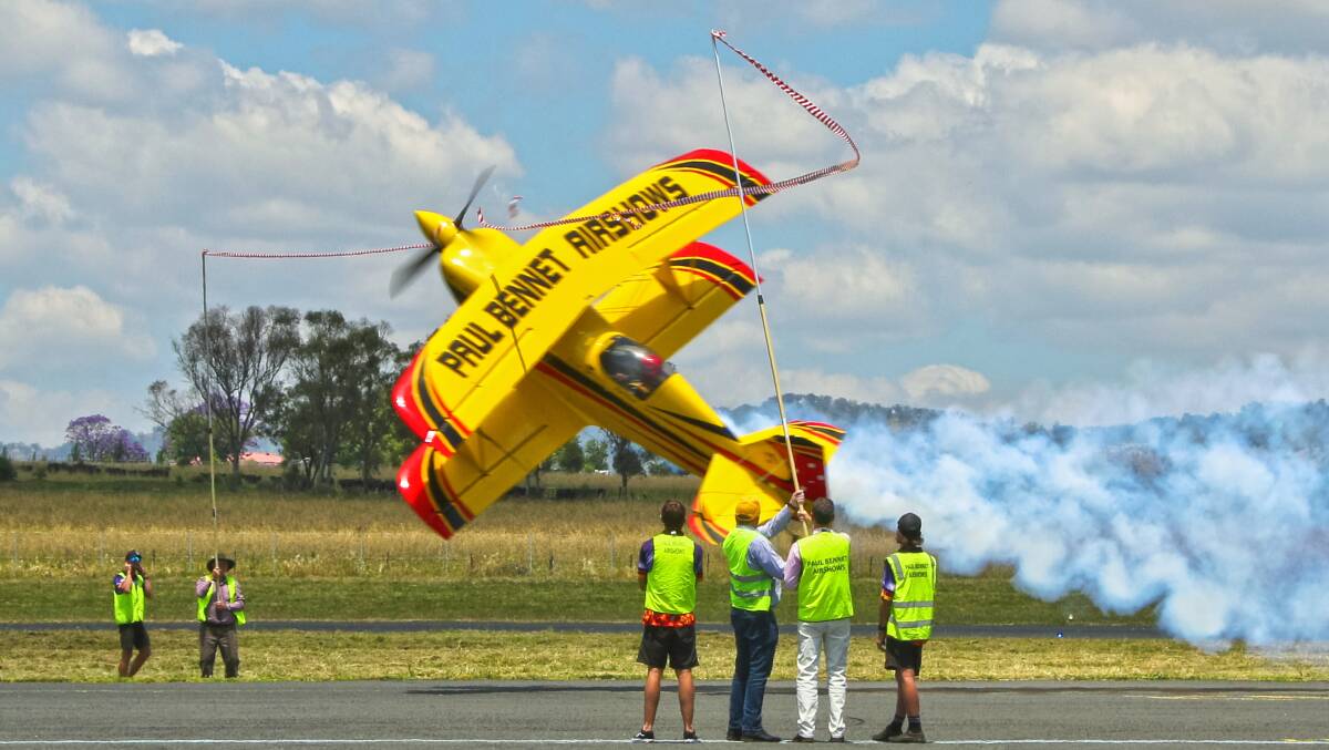 Hunter Valley aviation stunt professional Paul Bennet uses precision skill to cut the ribbon with his plane propellers and officially open Hunter Warbirds at the inaugural Festival of Flight at Scone Memorial Aerodrome on Saturday, November 26. Picture by Motty from Aviation Spotters Online.
