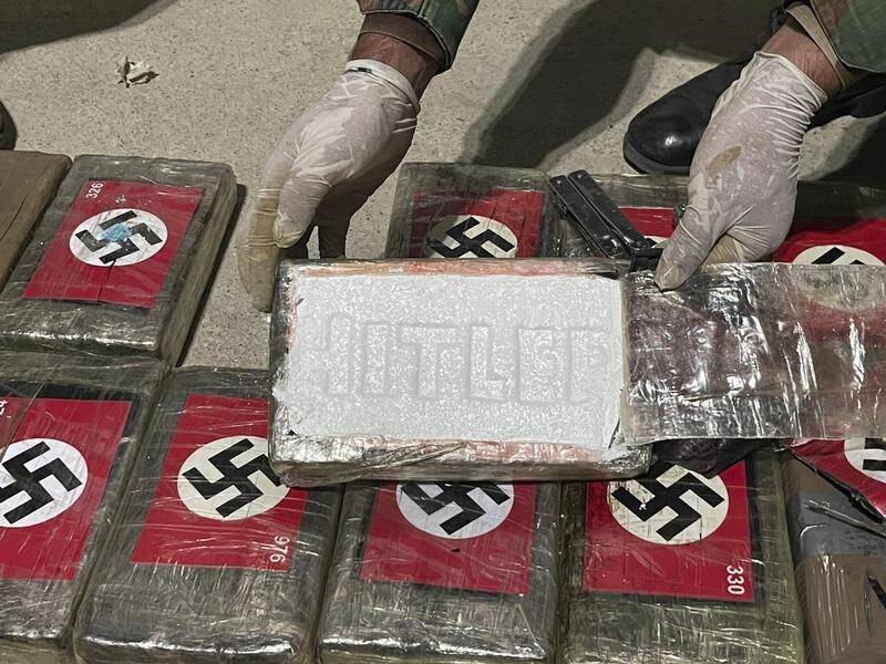 A Peruvian police officer shows cocaine blocks featuring Nazi swastikas and stamped with "HITLER". (AP)